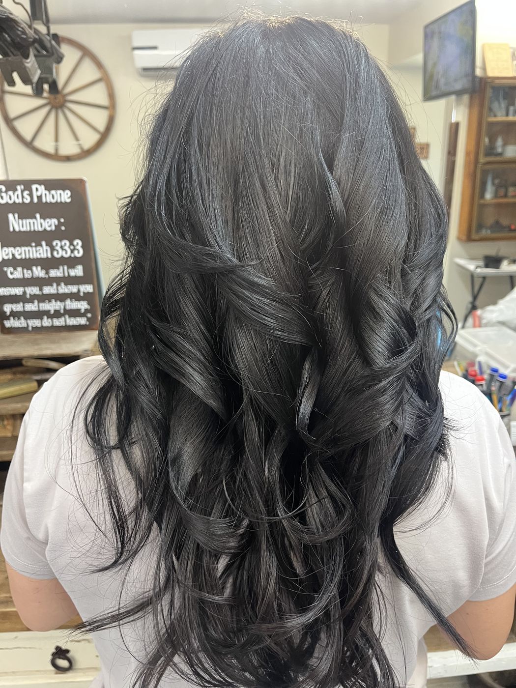 Layered cut with silver blended through darker hair, styled with soft waves
